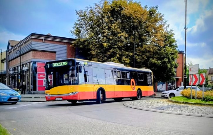 Autobus komunikacji miejskiej jadący przez rondo w mieście; na wyświetlaczu kierunek: Dworzec PKP.
